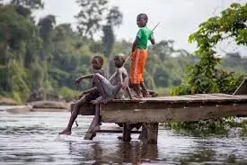 Kinderen in het binnenland van Suriname bij de rivier, symbool voor de logistieke uitdaging en het bereik van dit kinderboekproject